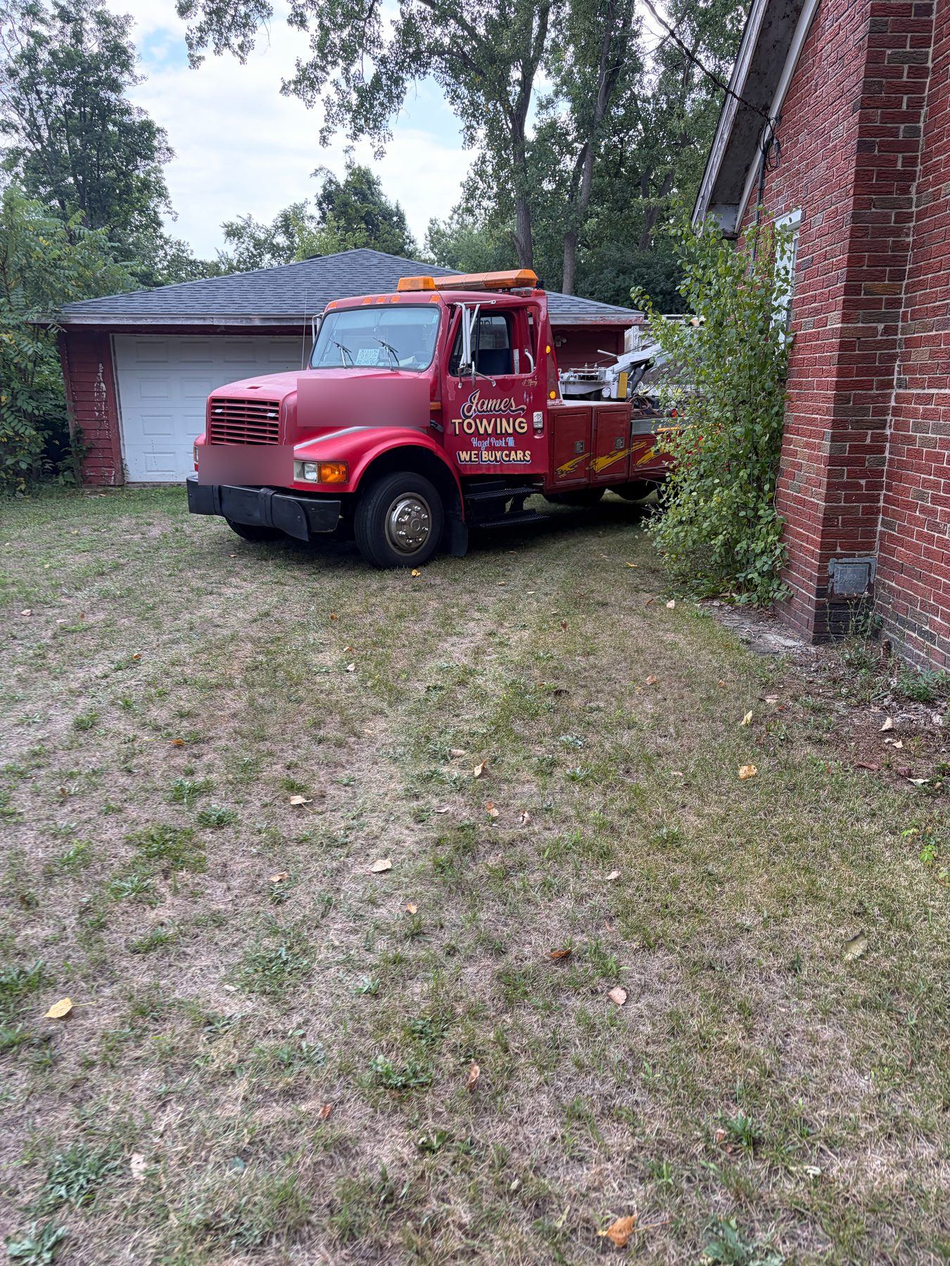 Red James Towing wrecker parked in a driveway